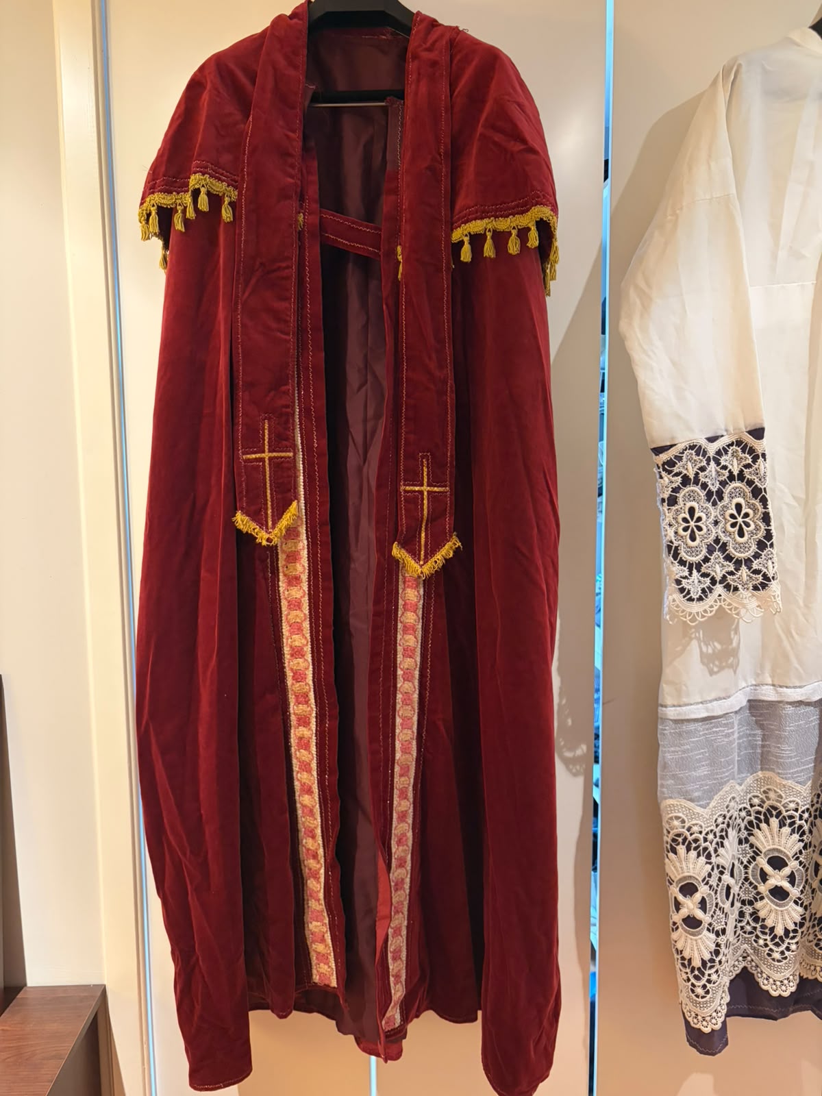 Rode Sinterklaasmantel met de witte albe/onderjurk ernaast